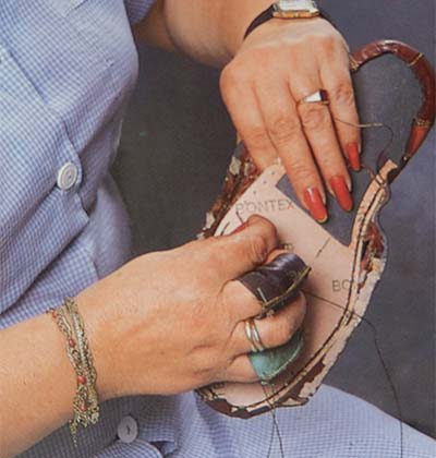 women's hands sewing shoes